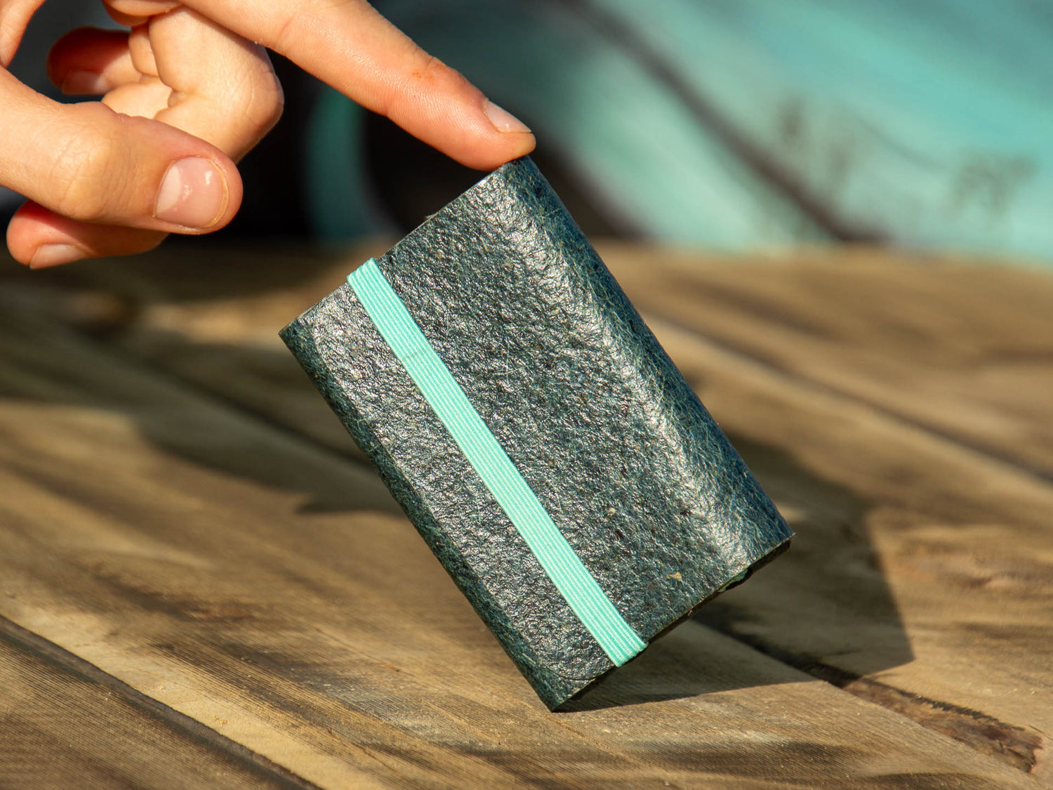  An image of our wallet in the captivating color of Dark Indigo, elegantly balanced on a wooden table.